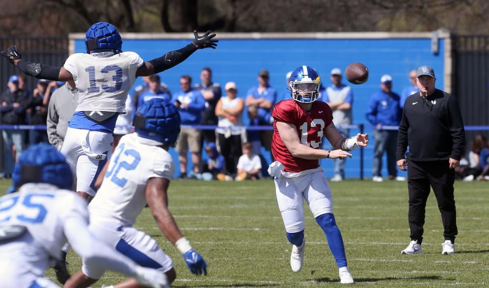 Kentucky’s Devin Leary throws the ball past J.J. Weaver (#13) during open practice for the fans on Saturday.April 1, 2023