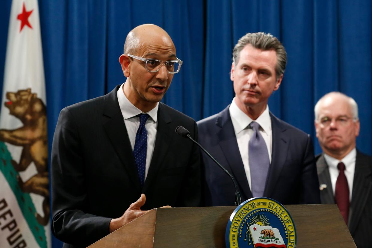 <p>FILE - In this March 12, 2020, file photo Dr. Mark Ghaly, secretary of the California Health and Human Services, discusses the coronavirus as Gov. Gavin Newsom, center, listens at a news conference in Sacramento, Calif. Sacramento area officials were caught off guard when the state public health agency lifted the regional stay-at-home order, allowing businesses like barber and beauty shops and nail salons, to reopen, restaurants to offer outdoor dining, and houses of worship to offer outdoor services. </p> (AP Photo/Rich Pedroncelli)