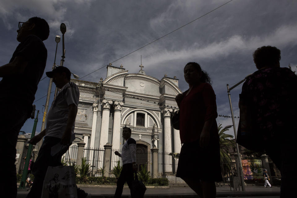 People walk along a busy pedestrian street in the historic center of Guatemala City, Friday, July 26, 2019. The Trump administration signed an agreement with Guatemala Friday that will restrict asylum applications to the U.S. from Central America. (AP Photo/ Oliver de Ros)