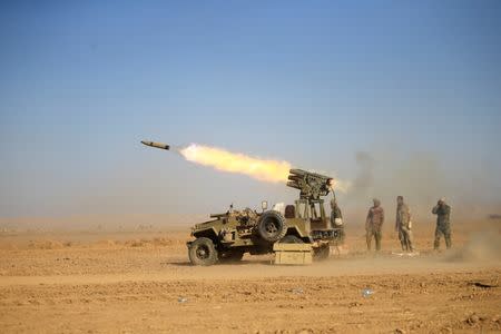 Shi'ite fighters fire a rocket towards Islamic State militants during a battle with Islamic State militants at the airport of Tal Afar west of Mosul, Iraq November 18, 2016. REUTERS/Thaier Al-Sudani