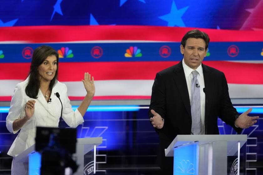 Republican presidential candidates former U.N. Ambassador Nikki Haley and Florida Gov. Ron DeSantis talk during a Republican presidential primary debate hosted by NBC News, Wednesday, Nov. 8, 2023, at the Adrienne Arsht Center for the Performing Arts of Miami-Dade County in Miami. (AP Photo/Rebecca Blackwell)