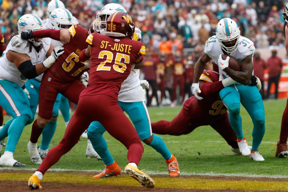 Dec 3, 2023; Landover, Maryland, USA; Miami Dolphins running back Raheem Mostert (31) scores a touchdown as Washington Commanders defensive tackle Jonathan Allen (93) during the second quarter at FedExField. Mandatory Credit: Geoff Burke-USA TODAY Sports