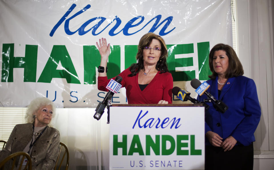 Former Alaska governor and 2008 Republican vice presidential nominee Sarah Palin, center, speaks at a county women's group meeting to campaign for Republican candidate for U.S. Senate Karen Handel, right, Thursday, April 3, 2014, in Union City, Ga. Palin is riding to the defense of the only Republican woman in the nomination fight for Georgia's open Senate seat, hitting back against GOP rival David Perdue's apparent dismissal of Karen Handel's high school education. (AP Photo/David Goldman)