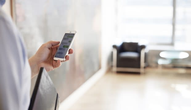 Businessman reading texts on phone, close-up