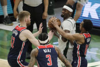 Milwaukee Bucks' Bobby Portis controls the ball while surrounded by Washington Wizards' Davis Bertans, Bradley Beal and Ish Smith, from left, during the first half of an NBA basketball game Wednesday, May 5, 2021, in Milwaukee. (AP Photo/Aaron Gash)