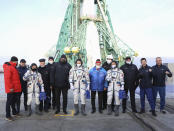 Roscosmos cosmonaut Alexander Misurkin, center, and spaceflight participants Japanese fashion tycoon Yusaku Maezawa, left in space suit, and Japanese producer Yozo Hirano, right, pose with members of the main crew of the new Soyuz mission to the International Space Station (ISS) pose with Roscosmos officials near the rocket prior the launch at the Russian leased Baikonur cosmodrome, Kazakhstan, Wednesday, Dec. 8, 2021. A Japanese billionaire and his producer rocketed to space Wednesday as the first self-paying space tourists in more than a decade. (Pavel Kassin/Roscosmos Space Agency via AP)