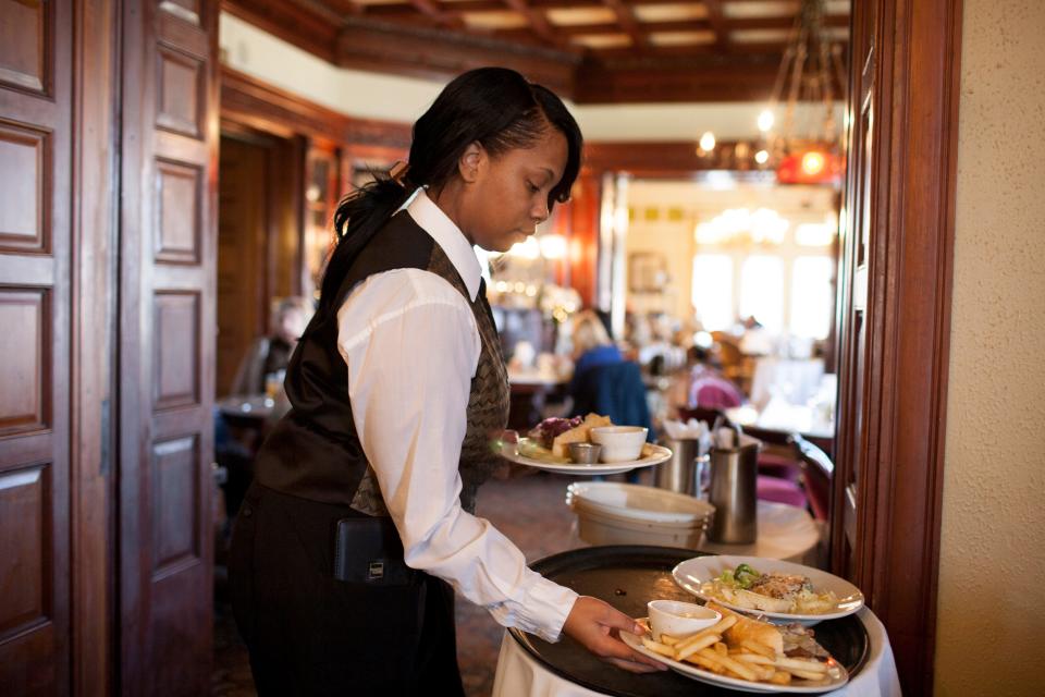 In this 2012 Tribune file photo, Brandi Gantt grabs a meal off a tray as she prepares to serve a few patrons on Friday, Nov. 16, 2012, at Tippecanoe Place. The restaurant, located in the former Studebaker family mansion, is open on Thanksgiving.