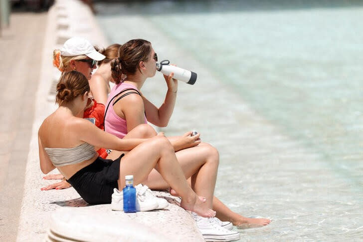 Varios turistas intentan refrescarse en la Ciudad de las Artes y las Ciencias durante la ola de calor en Valencia, España.