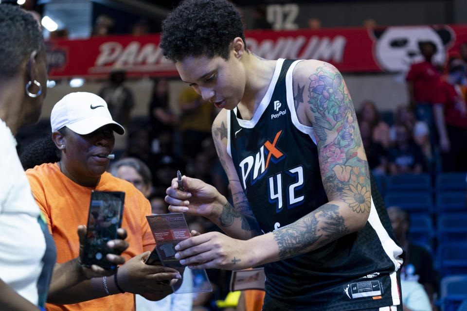 Phoenix Mercury center Brittney Griner (42) signs merch for fans after a WNBA basketball game against the Washington Mystics, Sunday, July 23, 2023, in Washington. (AP Photo/Stephanie Scarbrough)