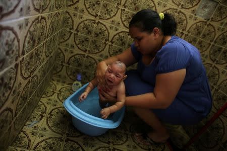 Jaqueline, 25, bathes her five-month-old daughter Laura at their house in Santos, Sao Paulo state, Brazil April 20, 2016. REUTERS/Nacho Doce