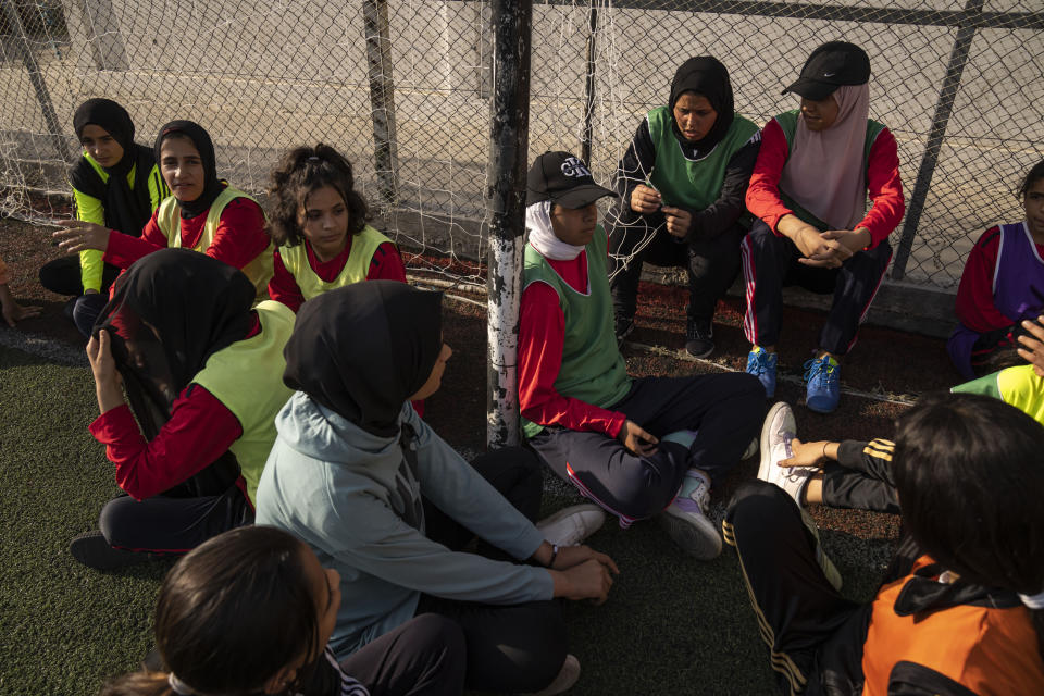 Palestinian girls take a break during a soccer training session at the Beit Hanoun Al-Ahli Youth Club's ground in the northern Gaza strip, Tuesday, Oct. 29, 2022. Women's soccer has been long been neglected in the Middle East, a region that is mad for the men's game and hosts the World Cup for the first time this month in Qatar. (AP Photo/Fatima Shbair)