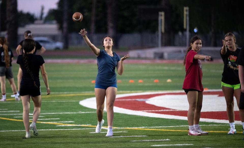 Athena Cantu throws the ball to a teammate during flag football team practice at Patterson High School in Patterson, Calif., Tuesday, August 1, 2023.