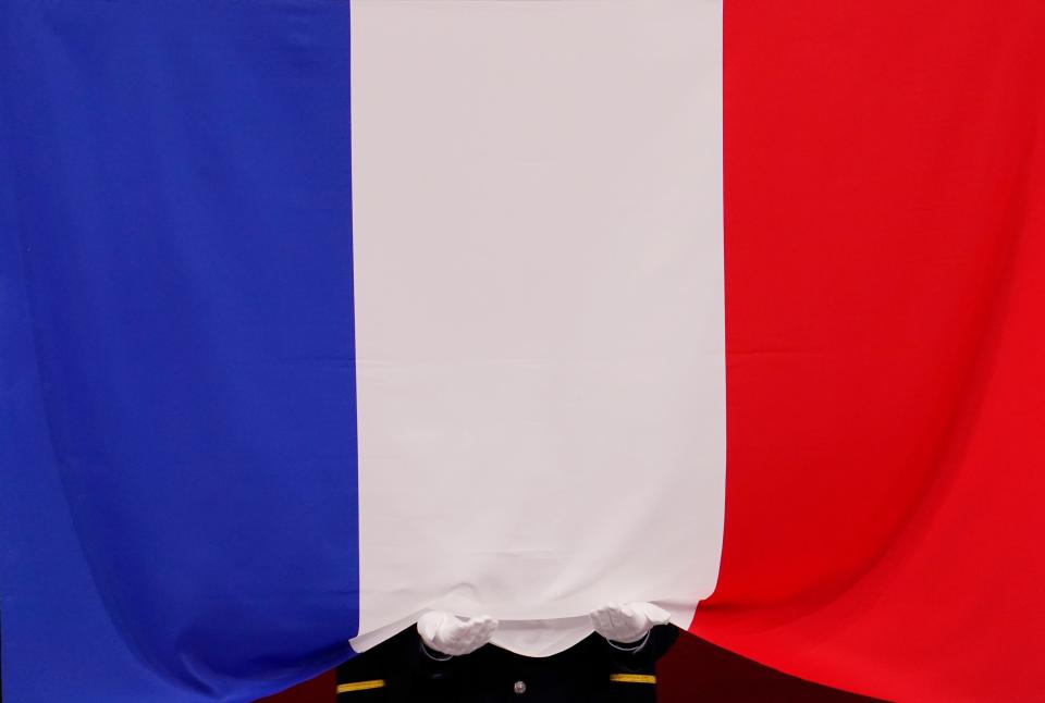 An official holds the French flag during judo competition at the Nippon Budokan in Tokyo on July 27, 2021. 