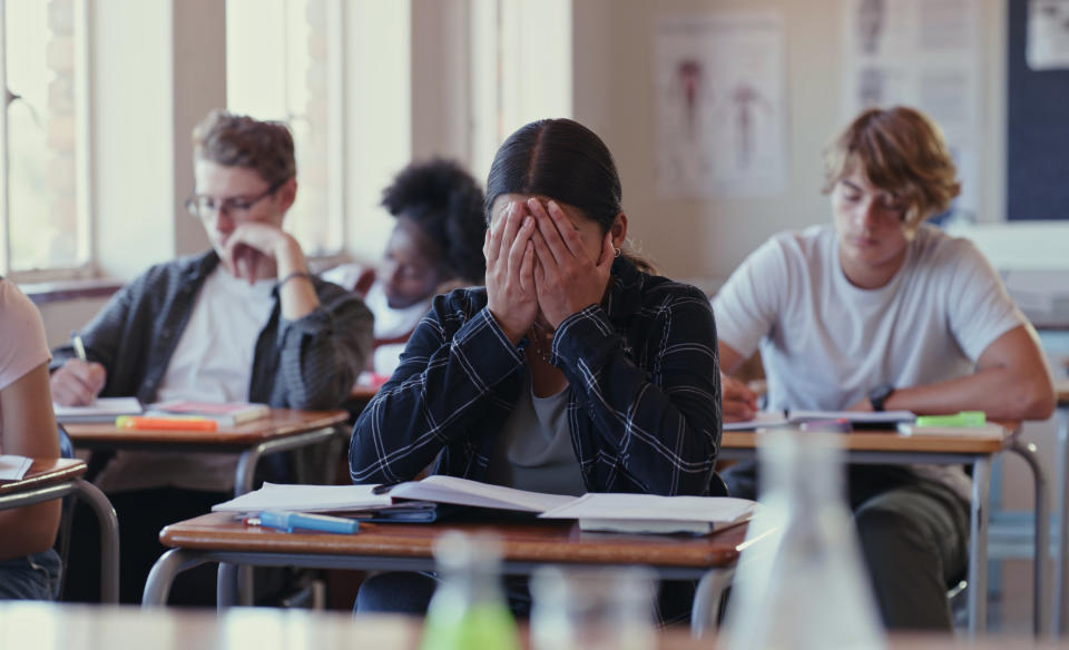 stressed out student covering her face with her hands