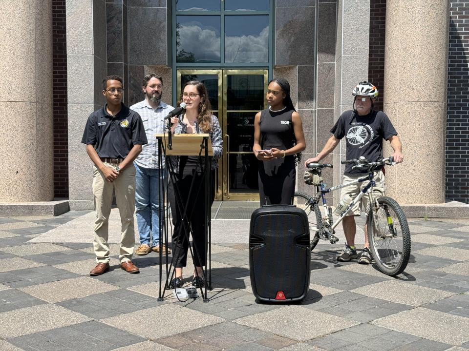 Elijah Hooks, Will Crowley, Loryn May, and Greg Wilson (left to right) all crowd around City Commissioner Jack Porter at her press conference urging for improved pedestrian and cyclist safety.