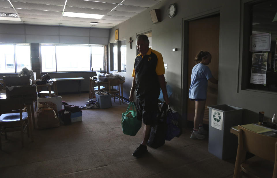 Timothy Waxenfelter, principal of Quigley Catholic High School, and his granddaughter Cesa Pusateri, 12, clean out his office after the recent closure of the school in Baden, Pa., Monday, June 8, 2020. The decision, announced by Bishop Zubik of Pittsburgh, was said to be based on declining enrollment, unsustainable cost projections and insufficient funds to assure the school's long-term viability. (AP Photo/Jessie Wardarski)