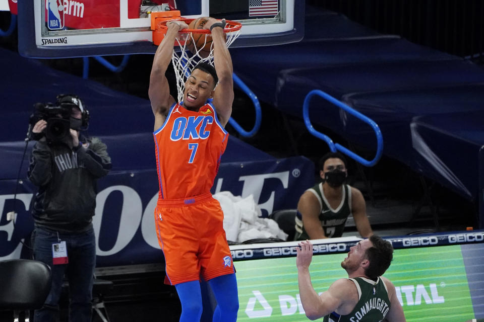 Oklahoma City Thunder forward Darius Bazley (7) dunks in front of Milwaukee Bucks guard Pat Connaughton, right, in the first half of an NBA basketball game Sunday, Feb. 14, 2021, in Oklahoma City. (AP Photo/Sue Ogrocki)