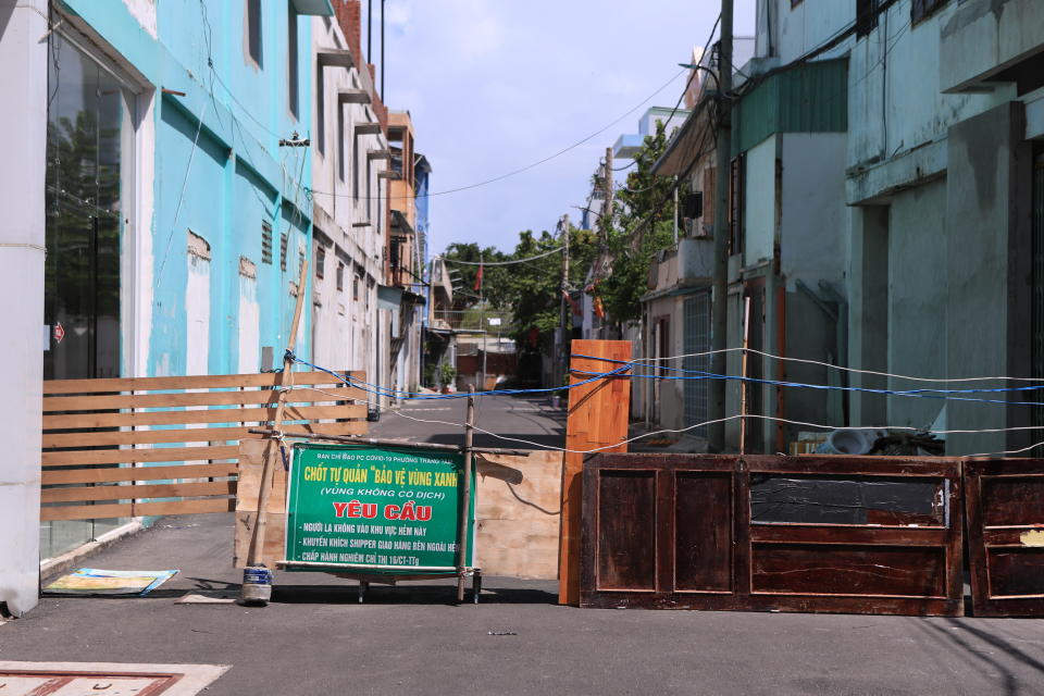 An alley is barricaded with door panels in Vung Tau, Vietnam, Monday, Sept. 20, 2021. In Vung Tau, just outside Ho Chi Minh city, streets are sealed and checkpoints are set up to control the movement of people. Barbed wire, door panels, steel sheets, chairs and tables are among materials being used to fence up alleys and isolate neighborhoods.(AP Photo/Hau Dinh)