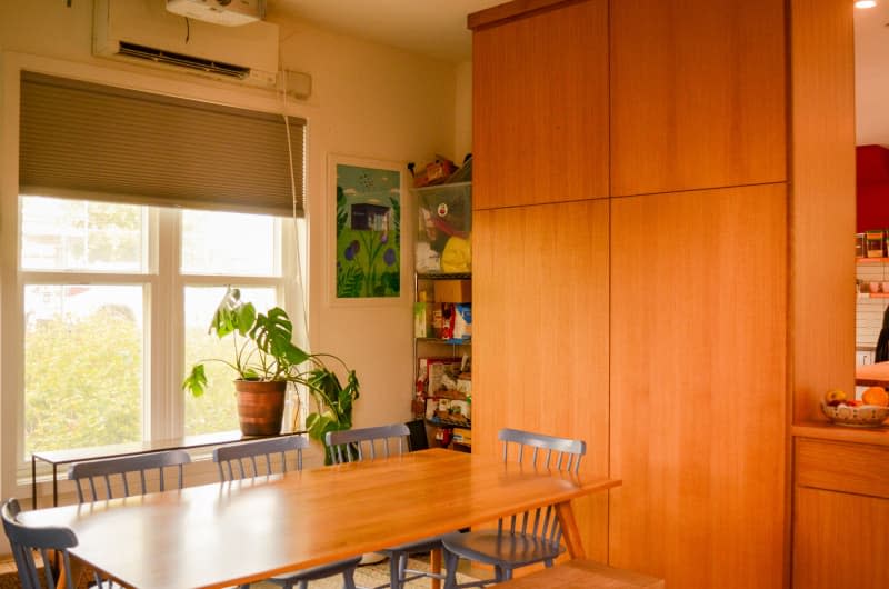 Wall length storage unit in dining room of communal home.