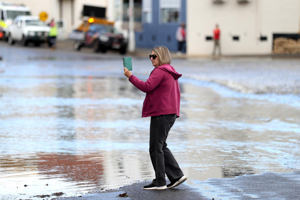 A woman takes photos of floodwaters in NSW on Friday. Source: Getty