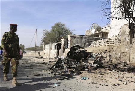 A Somali government soldier secures the scene of a suicide attack next to the gate of the Presidential Palace in Mogadishu February 21, 2014. REUTERS/Feisal Omar