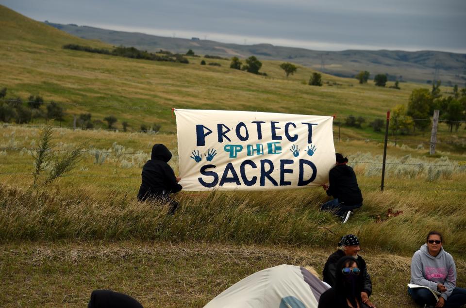 People hang a sign near a burial ground sacred site that was disturbed by bulldozers building the Dakota Access Pipeline (DAPL).