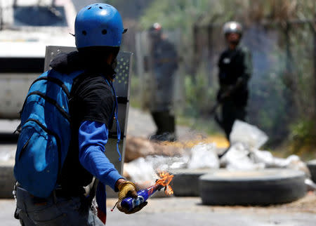 A demonstrator throws a Molotov cocktail at security forces during clashes at a rally against Venezuelan President Nicolas Maduro's government in Caracas, Venezuela, July 18, 2017. REUTERS/Andres Martinez Casares