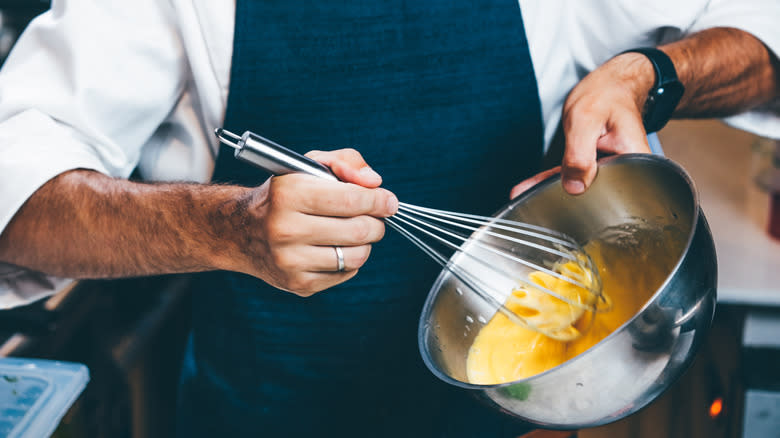 Whisking butter into hollandaise sauce