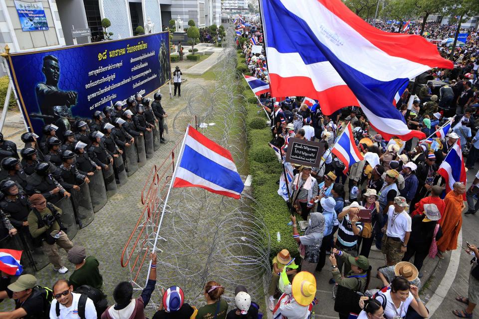 Thai anti-government protesters led by Suthep Thaugsuban confront line of soldiers outside the office of Permanent Secretary for Defense a temporary office of Prime Minister Yingluck Shinawatra on the outskirts of Bangkok, Thailand Wednesday, Feb. 19, 2014. Anti-government protesters have surrounded Yingluck's temporary office in Bangkok's northern outskirts to demand her resignation a day after clashes with police left at least five people dead. (AP Photo/Wason Wanichakorn)