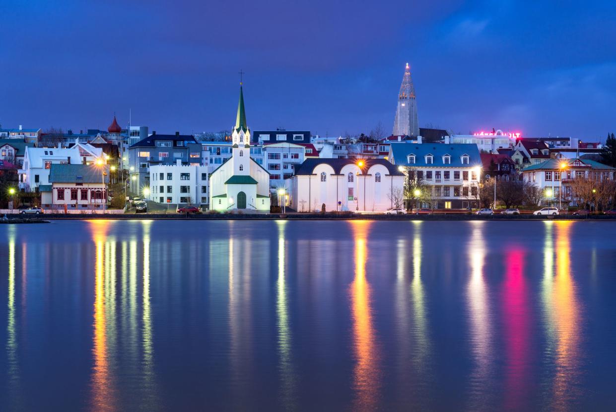 Cityscape of Reykjavik at dusk reflected in Lake Tjörnin, Hallgrimskirkja can be seen, Iceland, Europe