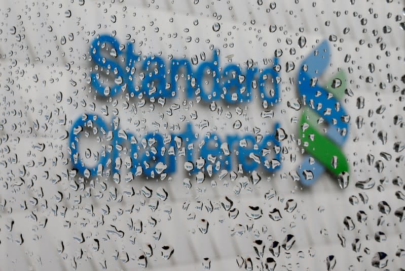 FILE PHOTO: A Standard Chartered logo at its headquarters is seen through a window with raindrops, in Hong Kong