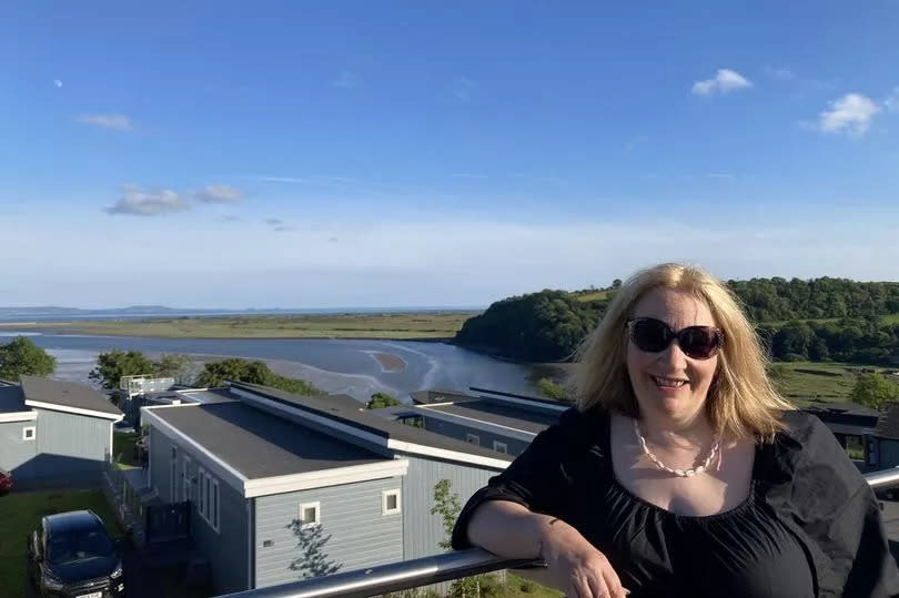 woman with view of holiday lodges and sea in background