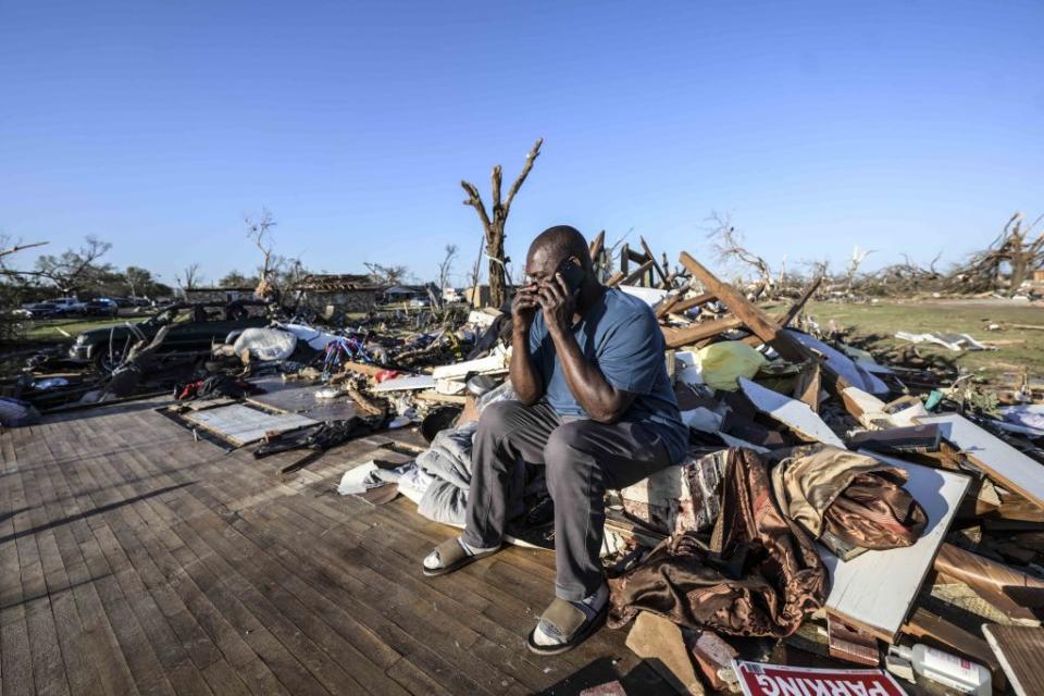 A resident sits amid the rubble after a tornado ripped through Mississippi.