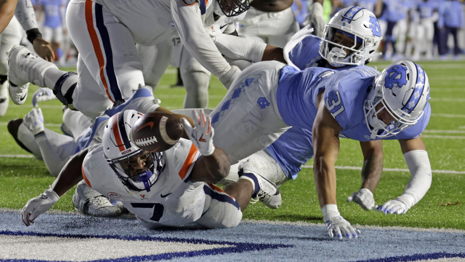 Virginia running back Mike Hollins (7) fumbles with North Carolina defensive back Will Hardy (31) nearby during the second half of an NCAA college football game, Saturday, Oct. 21, 2023, in Chapel Hill, N.C. The ball went out of the end zone and North Carolina took possession. (AP Photo/Chris Seward)