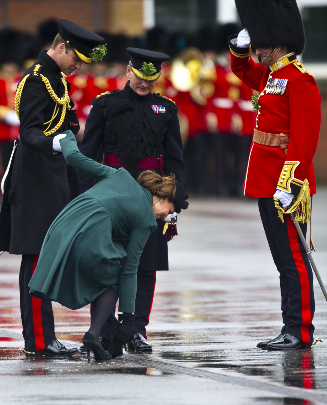 ALDERSHOT, ENGLAND - MARCH 17:  Prince William, Duke of Cambridge helps Catherine Duchess of Cambridge as her heel gets stuck in the grating during the Irish Guards' St Patrick's Day Parade at Mons Barracks on March 17, 2013 in Aldershot, England.  (Photo by Antony Jones/UK Press via Getty Images)