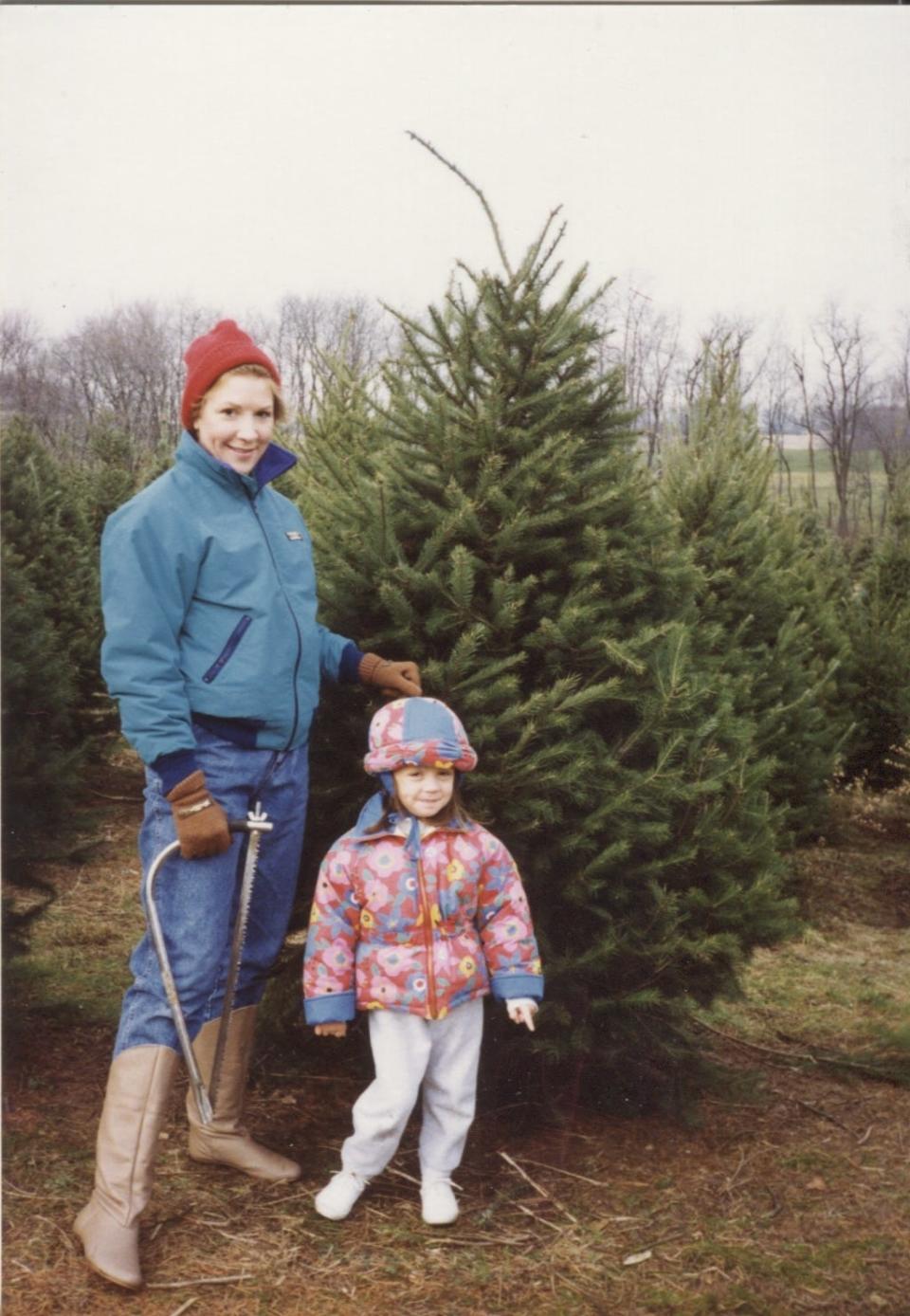 A childhood photo shows Ashley May posing with her mom before they cut down their Christmas tree. (They didn't actually cut it down. Props go to Ashley's dad for that.)