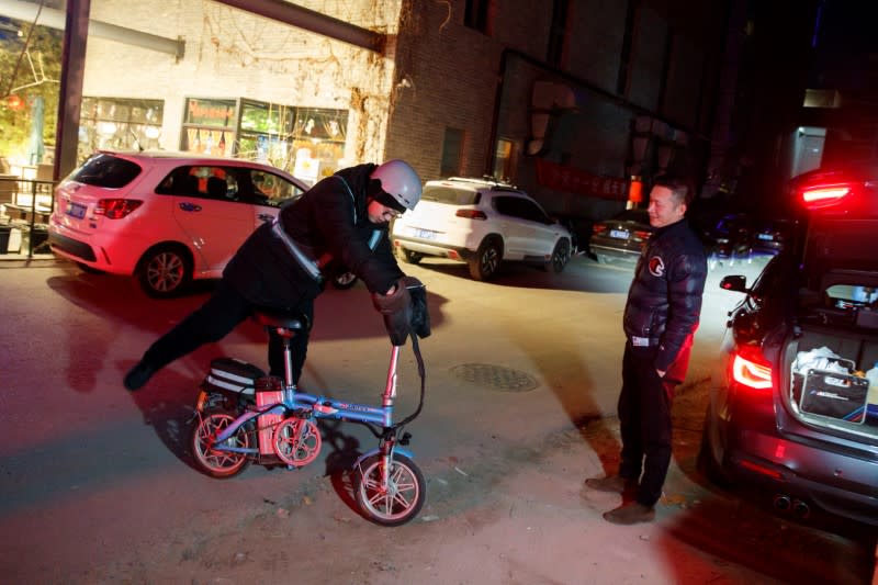 Liu Pengfei, a substitute driver of ride-hailing service platform DiDi Chuxing, meets a client outside a restaurants in Beijing