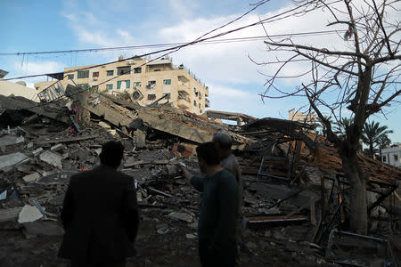 Palestinians stand near the remains of a building that was destroyed in Israeli air strikes, in Gaza City May 5, 2019. REUTERS/Suhaib Salem