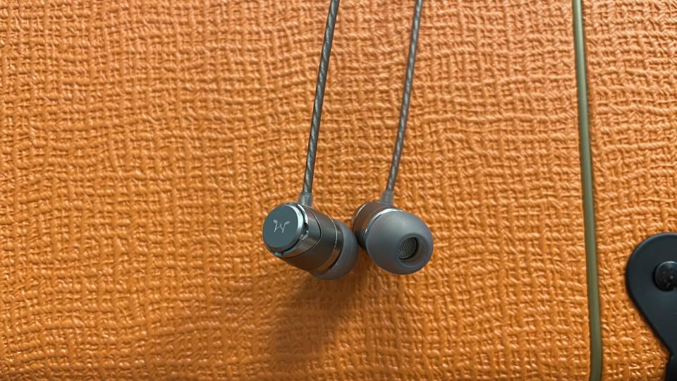 SoundMagic E11D hanging down against orange background