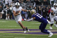 Michigan State quarterback Payton Thorne runs downfield against Washington linebacker Kamren Fabiculanan during the first half of an NCAA college football game, Saturday, Sept. 17, 2022, in Seattle. Washington won 39-28. (AP Photo/Stephen Brashear)