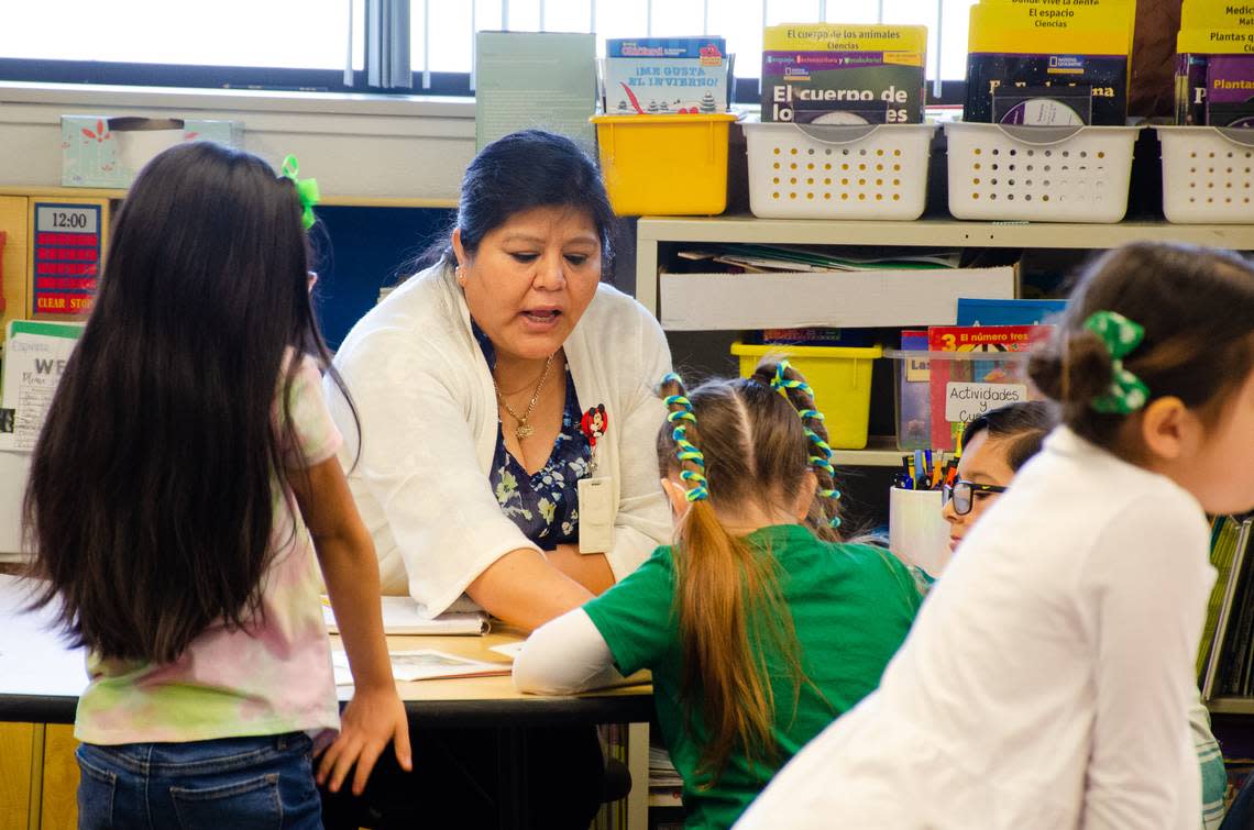 Kindergarten dual language teacher Minerva Espinoza walks students through their school work last week at Mark Twain Elementary School. The school has a combined six classrooms of K-2 students involved in dual language learning, and it plans on expanding into 3rd grade next year.