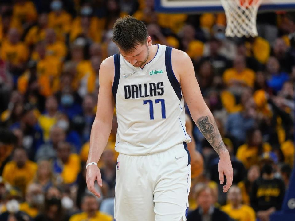 Luka Doncic walks with his head down during a game.