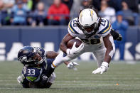 <p>Melvin Gordon III #28 of the Los Angeles Chargers runs with the ball while being tackled by Tedric Thompson #33 of the Seattle Seahawks in the fourth quarter at CenturyLink Field on November 04, 2018 in Seattle, Washington. (Photo by Abbie Parr/Getty Images) </p>