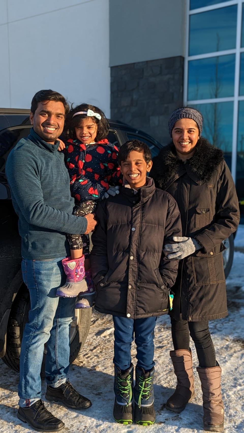 Sumesh Pulavathil and Gayathri Ramdas pose for a photo with their two children. 