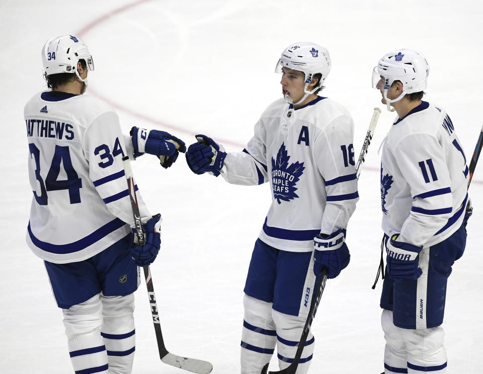 Toronto Maple Leafs right wing Mitchell Marner (16) celebrates his empty-net goal against the Ottawa Senators with center Auston Matthews (34) and left wing Zach Hyman (11) during third-period NHL hockey game action in Ottawa, Ontario, Saturday, Feb. 15, 2020. (Justin Tang/The Canadian Press via AP)