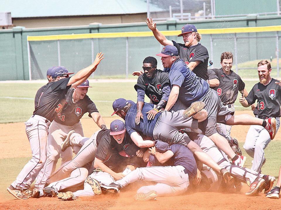 Oklahoma Wesleyan University baseball players and coaches storm the mound for a dogpile after the Eagles won a NAIA regional title in 2017 and advanced to the NAIA World Series.