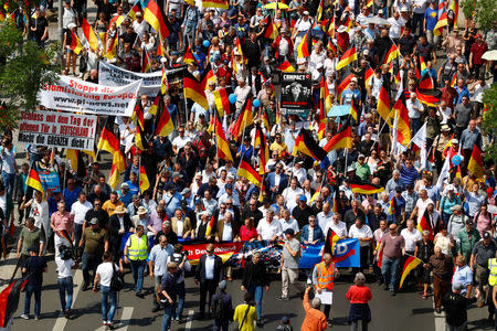 FILE PHOTO: Supporters of the Anti-immigration party Alternative for Germany (AfD) hold German flags during a protest in Berlin, Germany, May 27, 2018. REUTERS/Hannibal Hanschke/File Photo