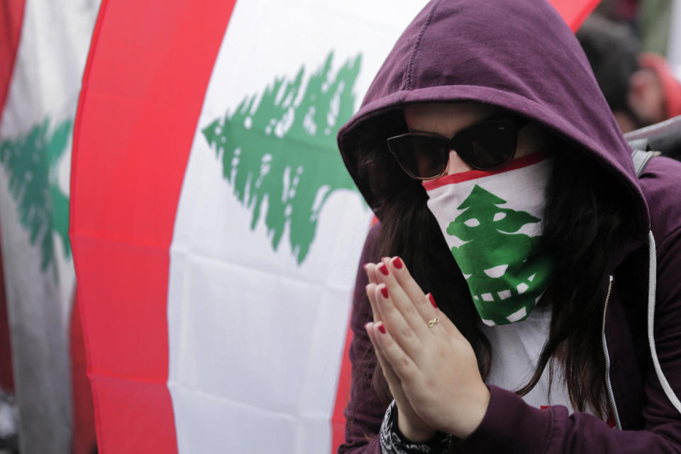 An anti-government protester reacts while listening to Lebanon's President Michel Aoun on speaker while he addressees the nation during a protest in the town of Jal el-Dib north of Beirut, Lebanon, Thursday, Oct. 24, 2019. Aoun has told tens of thousands of protesters that an economic reform package put forth by the country's prime minister will be the "first step" toward saving Lebanon from economic collapse. (AP Photo/Hassan Ammar)