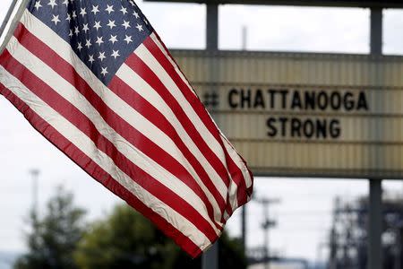 U.S. flag flies alongside a sign in honor of the four Marines killed in Chattanooga, Tennessee July 17, 2015. REUTERS/Tami Chappell