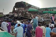 <p>Local residents gather to observe the crash site after two trains (one passenger and the other commercial) collided in Pakistan. 11 people were killed and around 80 people were injured.</p>